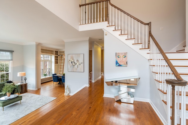 stairway with wood-type flooring and ornamental molding