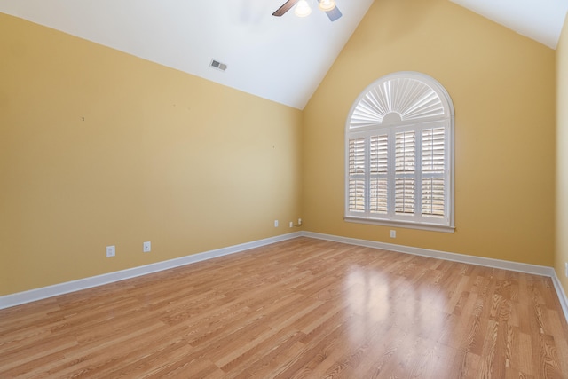 empty room with ceiling fan, vaulted ceiling, and light wood-type flooring