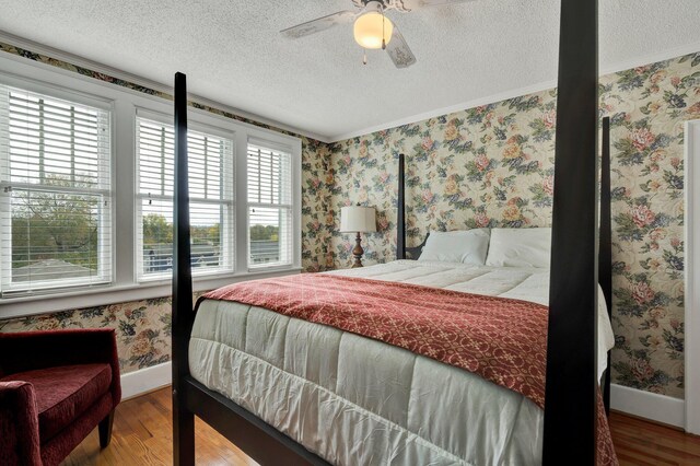 431 Highland Ave NW, Cleveland, TN 37311 - bedroom with wood finished floors, a textured ceiling, ornamental molding, ceiling fan, and wallpapered walls