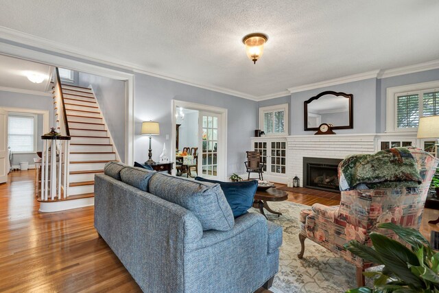 431 Highland Ave NW, Cleveland, TN 37311 - living area featuring wood finished floors, stairway, crown molding, a brick fireplace, and a textured ceiling