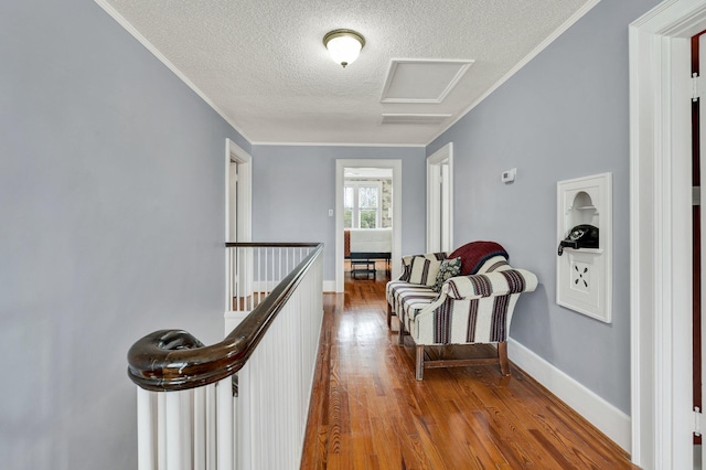 431 Highland Ave NW, Cleveland, TN 37311 - hallway featuring a textured ceiling, wood finished floors, an upstairs landing, attic access, and ornamental molding