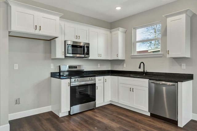 kitchen with stainless steel appliances, white cabinetry, dark hardwood / wood-style floors, and sink