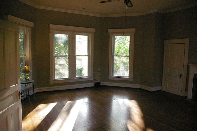 unfurnished room with baseboards, ornamental molding, and dark wood-type flooring