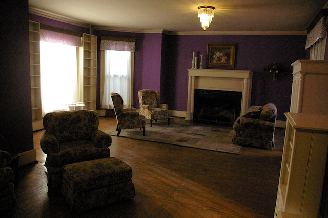 sitting room with a fireplace, wood finished floors, and crown molding