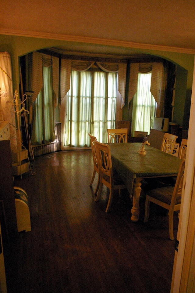 dining space with crown molding and wood finished floors