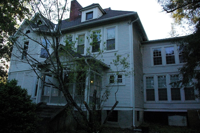 view of home's exterior featuring a chimney and a sunroom