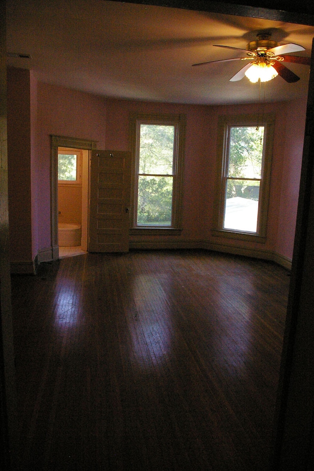 empty room featuring ceiling fan, hardwood / wood-style floors, and a healthy amount of sunlight