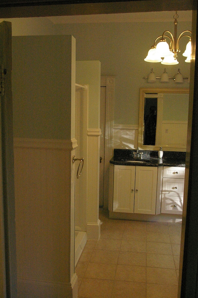 bathroom with wainscoting, a shower stall, vanity, and tile patterned floors