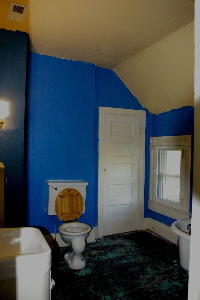 bathroom featuring toilet, visible vents, and lofted ceiling