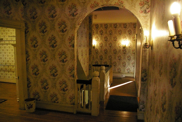 bathroom with wallpapered walls, baseboards, and wood finished floors