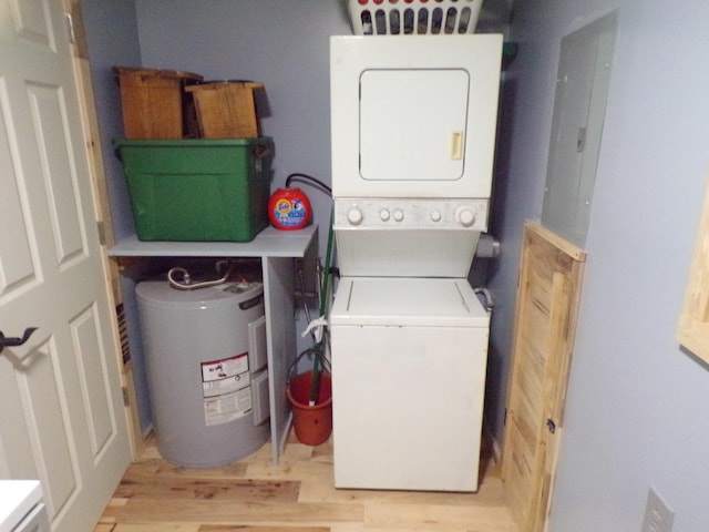 laundry area featuring stacked washer / dryer, electric water heater, and light hardwood / wood-style floors