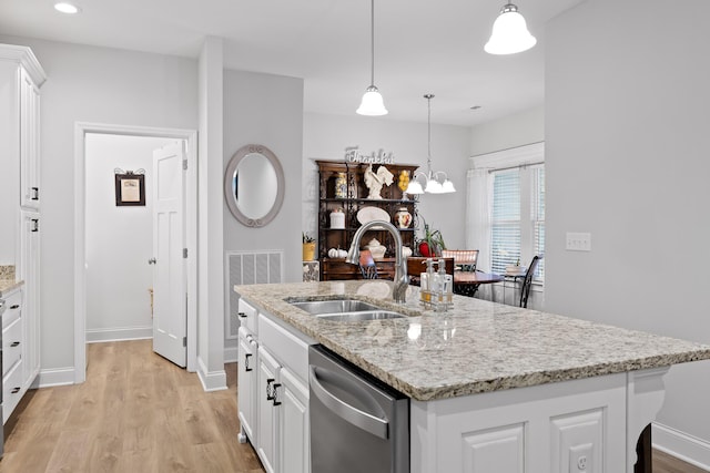 kitchen with decorative light fixtures, white cabinetry, dishwasher, sink, and a kitchen island with sink