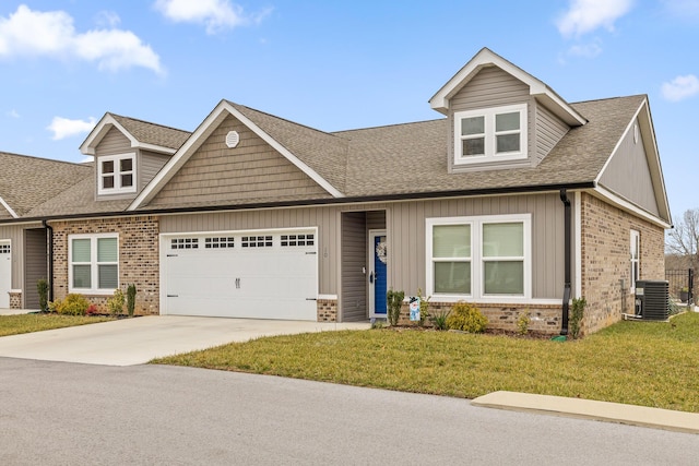 view of front facade featuring a garage, central AC, and a front yard