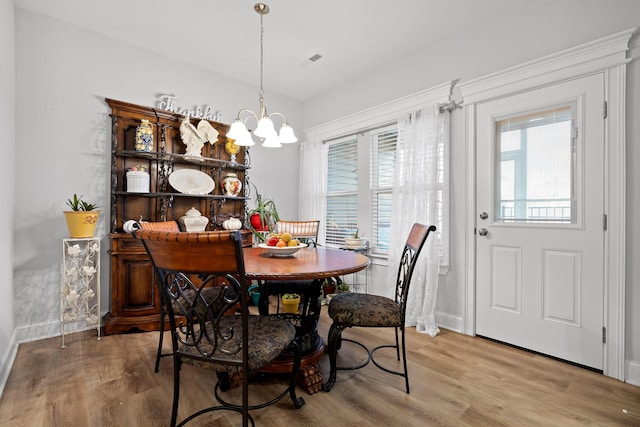 dining area with an inviting chandelier and wood-type flooring