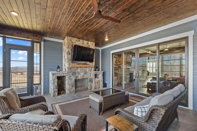 living room with an outdoor stone fireplace, wooden ceiling, and ceiling fan