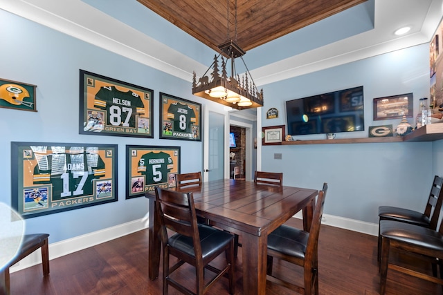 dining space with a raised ceiling and dark hardwood / wood-style floors