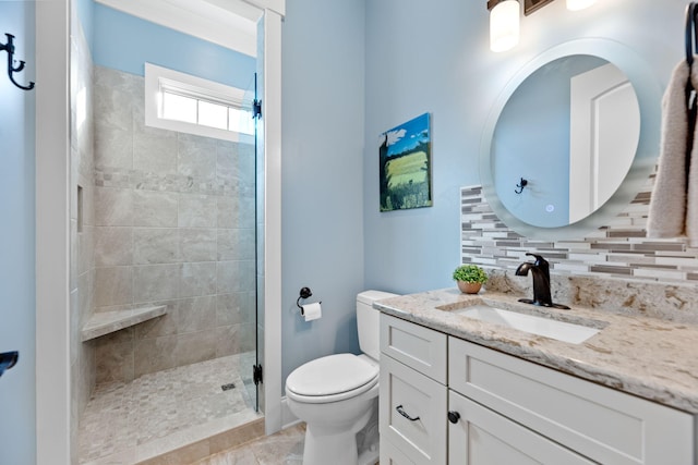 bathroom featuring tasteful backsplash, tiled shower, vanity, and toilet
