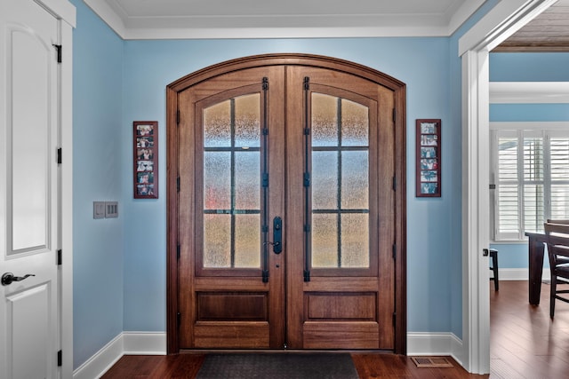 foyer entrance with ornamental molding, dark hardwood / wood-style floors, and french doors
