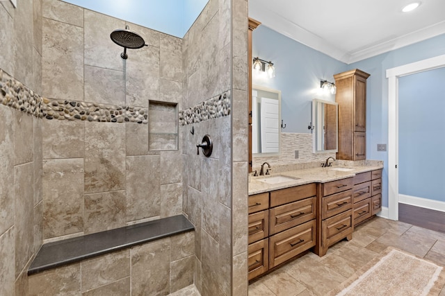 bathroom featuring tiled shower, vanity, decorative backsplash, and ornamental molding