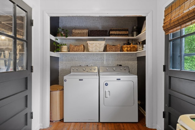 laundry area featuring washing machine and clothes dryer, laundry area, and wood finished floors