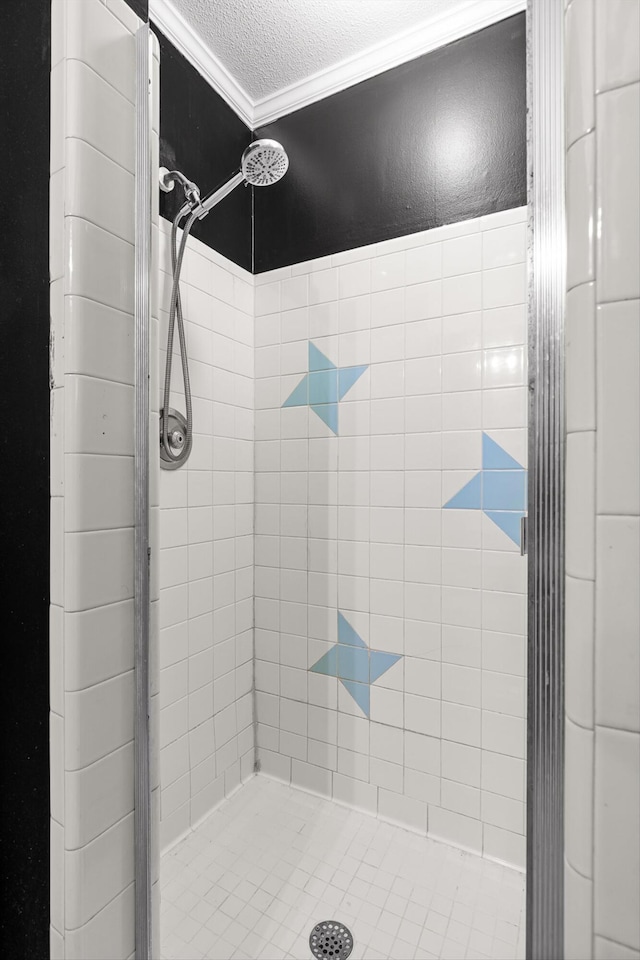 bathroom with a stall shower, ornamental molding, and a textured ceiling