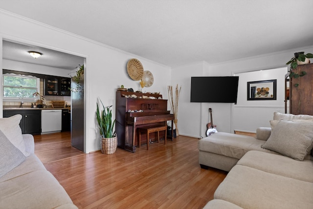 living area with crown molding and light wood-type flooring