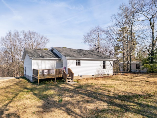 rear view of property featuring a deck and a lawn