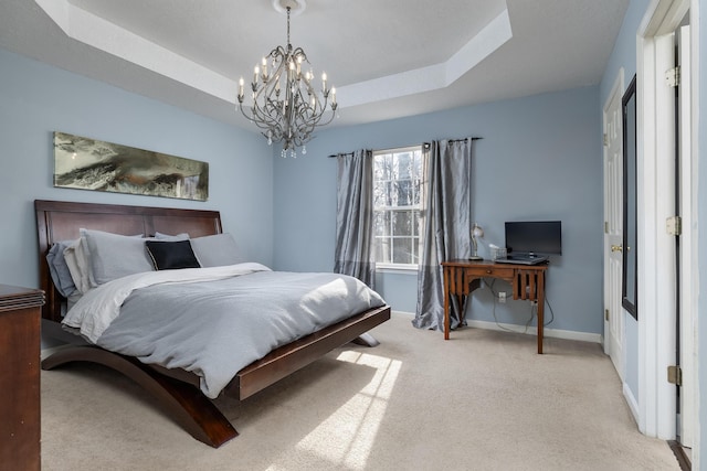 carpeted bedroom with an inviting chandelier and a raised ceiling