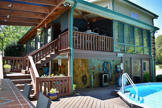 1150 Pin Hook Rd, Spring City, TN 37381 - back of property with a sunroom, stairway, stone siding, a wooden deck, and an outdoor pool