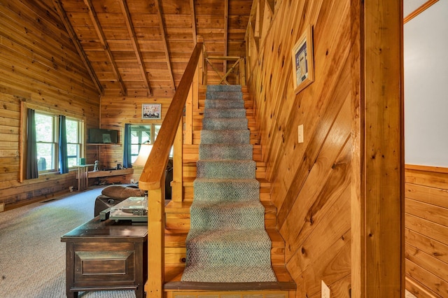 stairway with carpet flooring, wood ceiling, lofted ceiling, and wooden walls