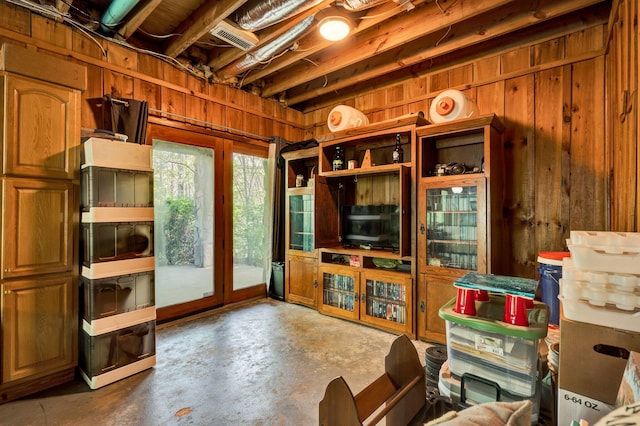 living area featuring wood walls, concrete floors, and visible vents