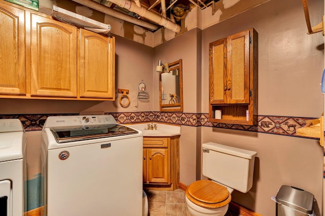 bathroom featuring a sink, separate washer and dryer, and toilet