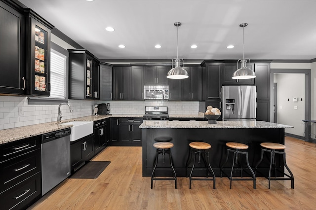 1422 Adams St, Chattanooga, TN 37408 - kitchen featuring stainless steel appliances, a sink, dark cabinetry, a breakfast bar area, and a kitchen island