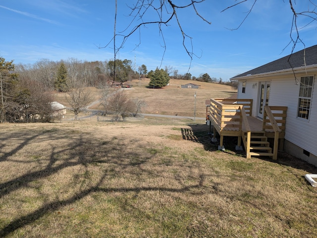 view of yard with a wooden deck and a rural view