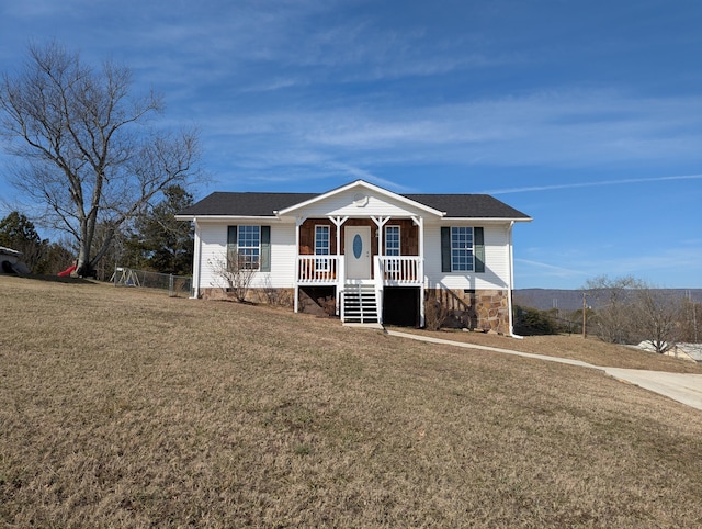 ranch-style house featuring covered porch and a front lawn