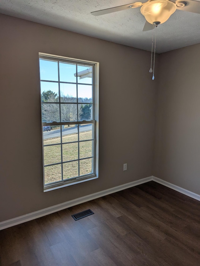 spare room with ceiling fan, dark hardwood / wood-style flooring, and a textured ceiling