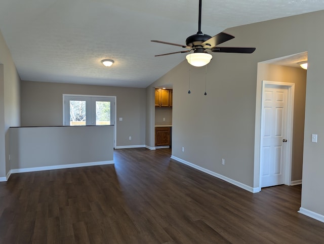 spare room with ceiling fan, lofted ceiling, dark hardwood / wood-style flooring, and a textured ceiling