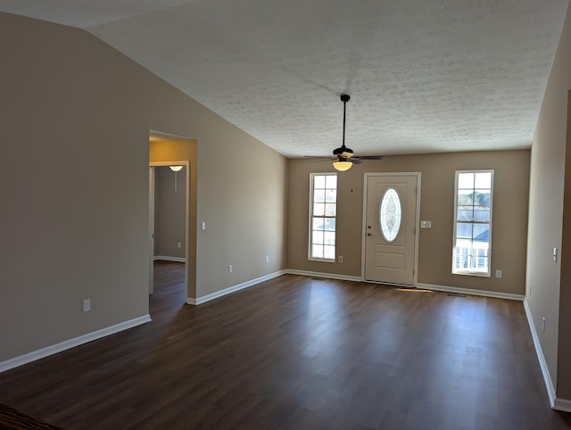 entryway with ceiling fan, dark hardwood / wood-style flooring, vaulted ceiling, and a wealth of natural light