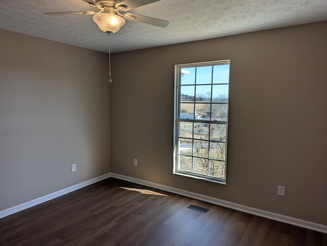 spare room featuring a textured ceiling, dark wood-type flooring, and ceiling fan