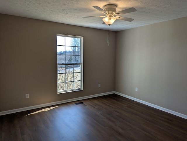 empty room featuring dark wood-type flooring, ceiling fan, and a textured ceiling