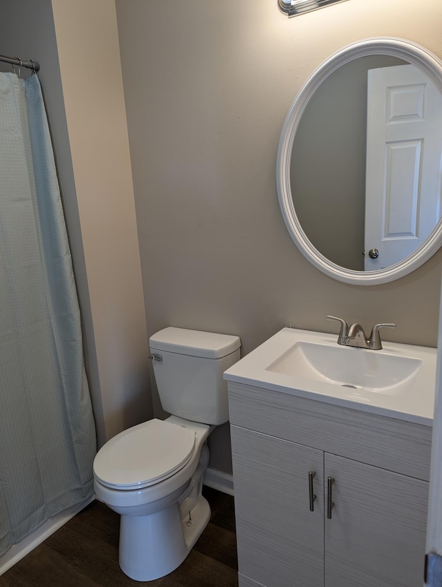 bathroom featuring vanity, wood-type flooring, and toilet