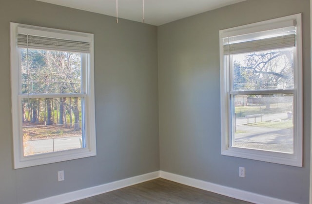 unfurnished room with plenty of natural light and dark hardwood / wood-style floors