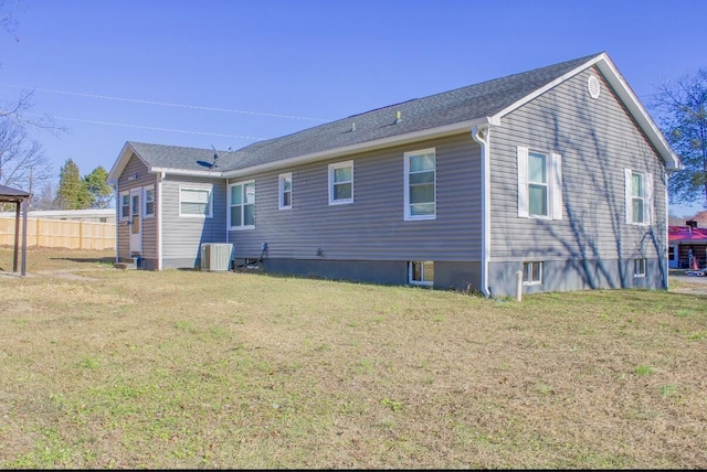 back of house with a yard and central AC