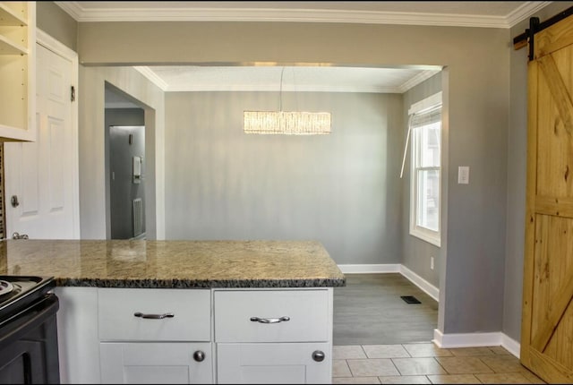 kitchen featuring white cabinets, a barn door, light wood-type flooring, and crown molding