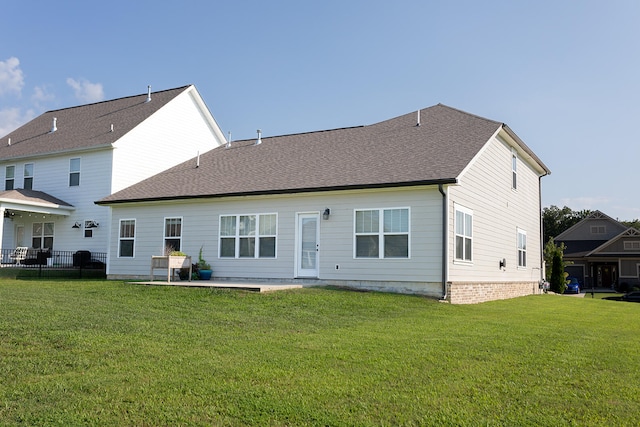 back of property with a lawn and a patio