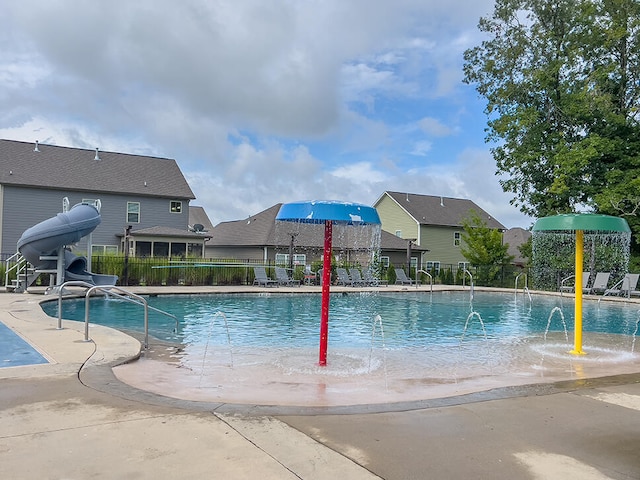 view of swimming pool featuring a patio area, pool water feature, and a water slide