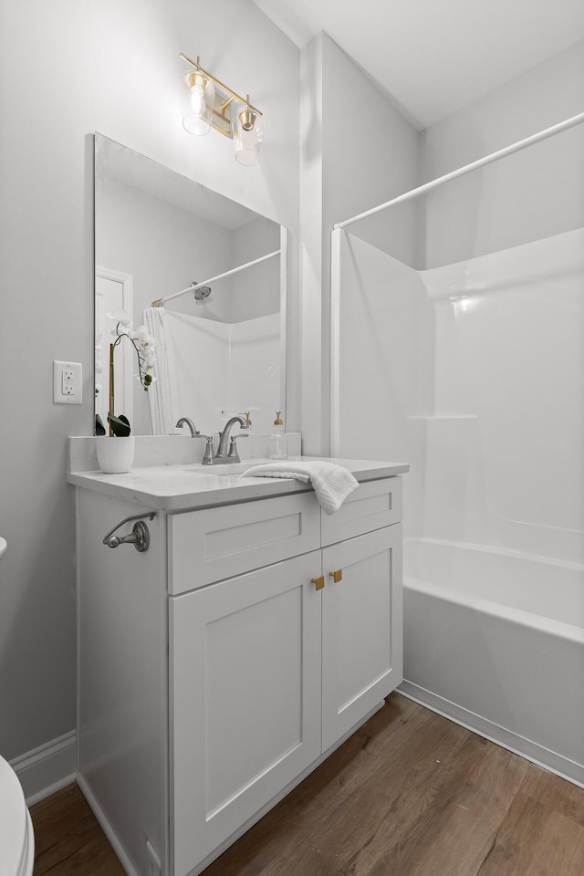 full bath featuring vanity, toilet, shower / washtub combination, and wood finished floors