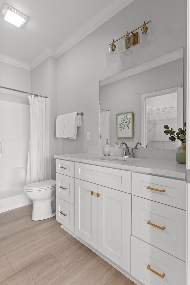 full bathroom featuring toilet, ornamental molding, curtained shower, vanity, and wood finished floors