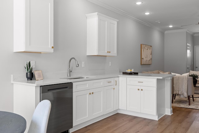kitchen with a sink, a peninsula, dishwasher, crown molding, and light wood finished floors