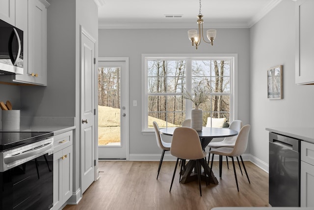 dining area featuring a wealth of natural light, light wood-style floors, and ornamental molding